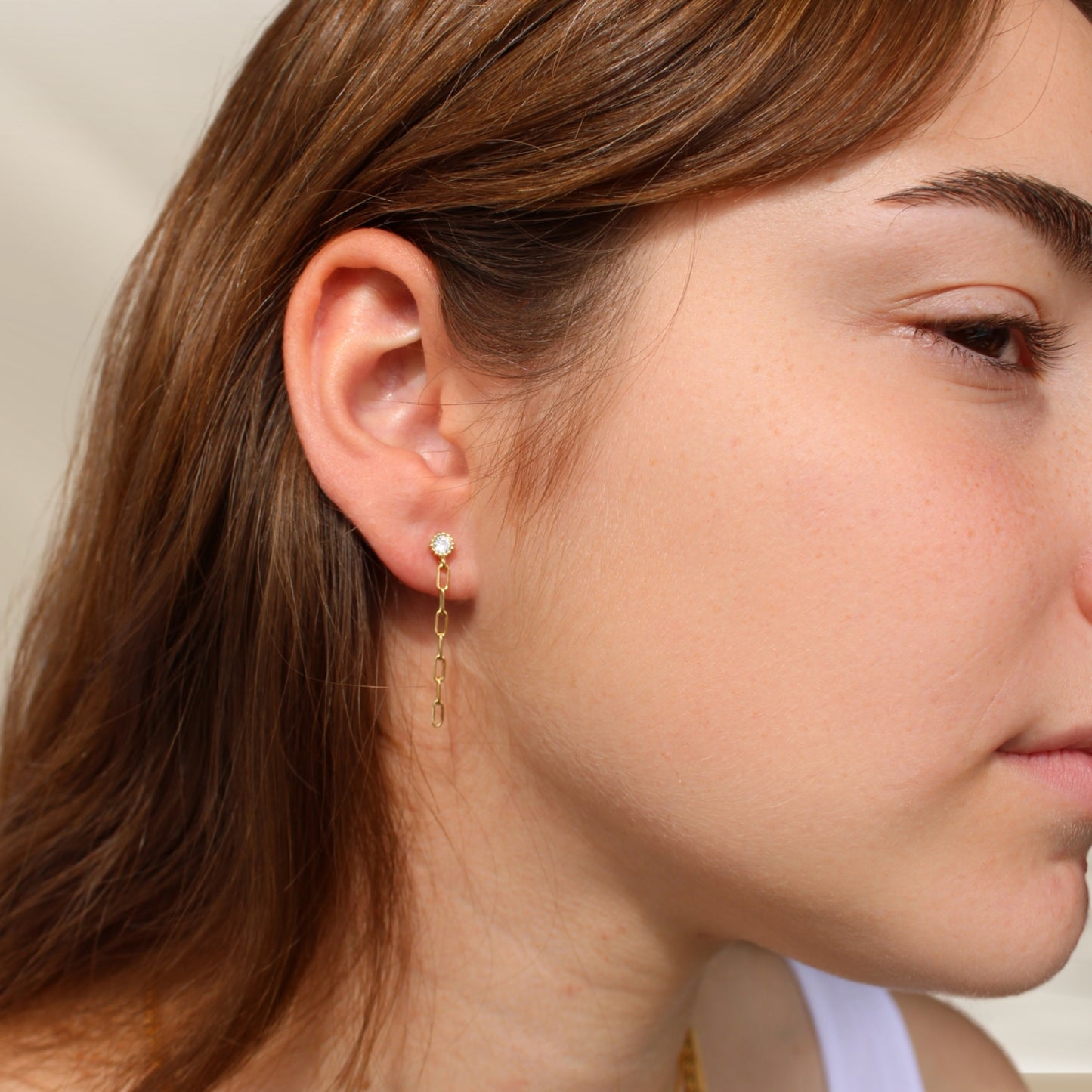 דוגמנית עונדת עגיל צמוד שרשרת זהב משובץ זירקון