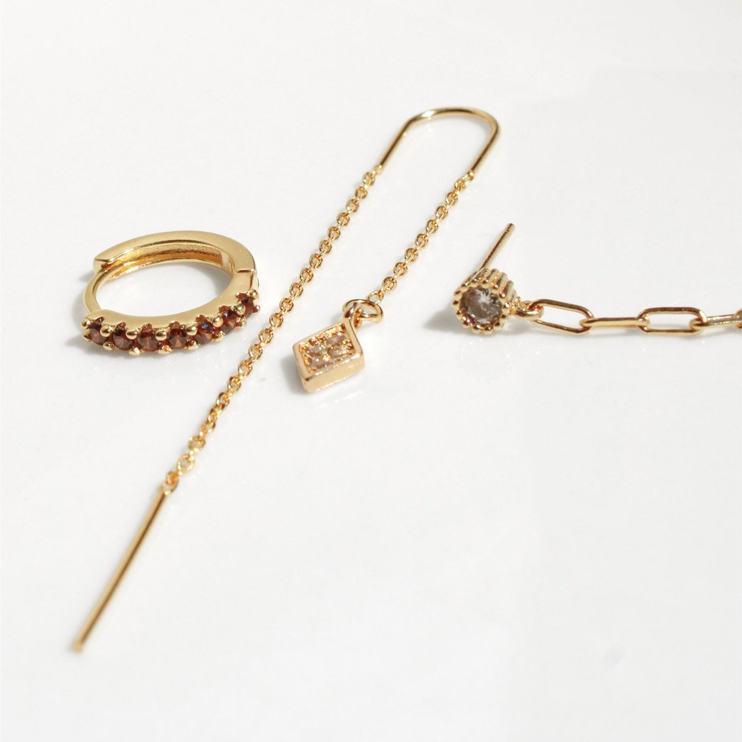 סט עגילים מוזהבים עם שילוב של חישוק משובץ, עגיל צמוד עם אבן, עגיל שרשרת עם תליון, ועגיל חוליות – עיצוב מודרני לאוזן עם כמה חורים